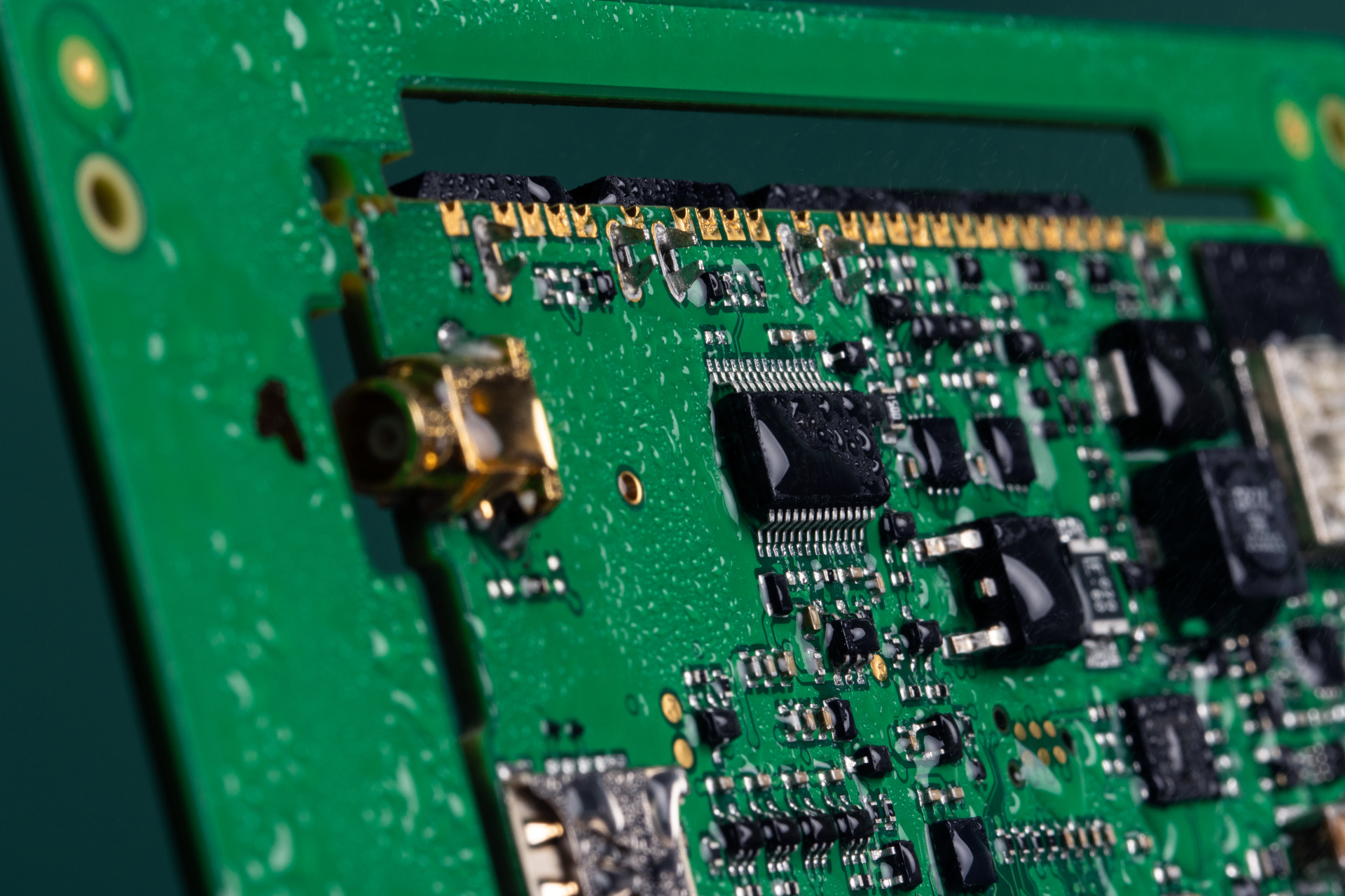 A circuit board with droplets of water covering the surface